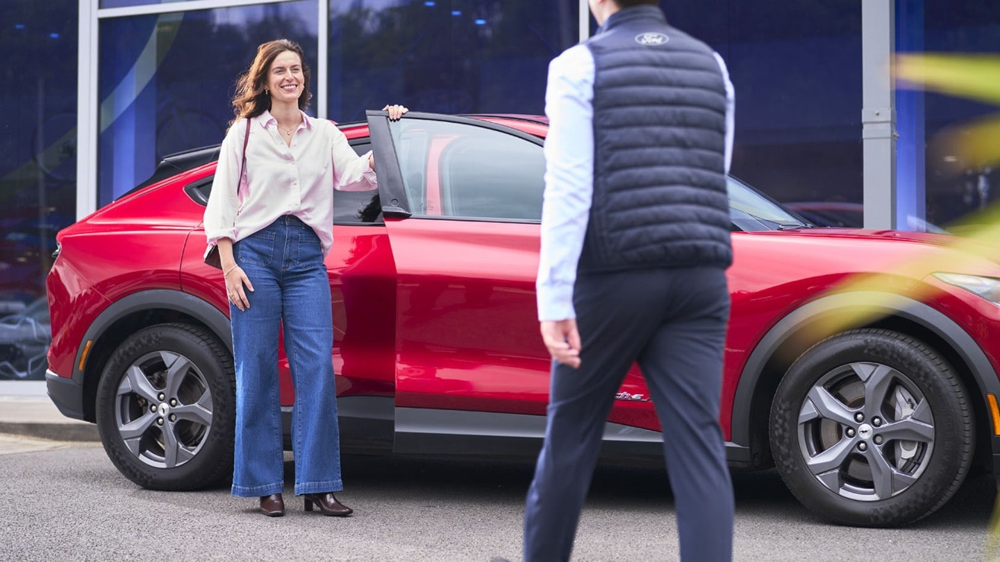 Cliente davanti una Mustang Mach-E rossa.