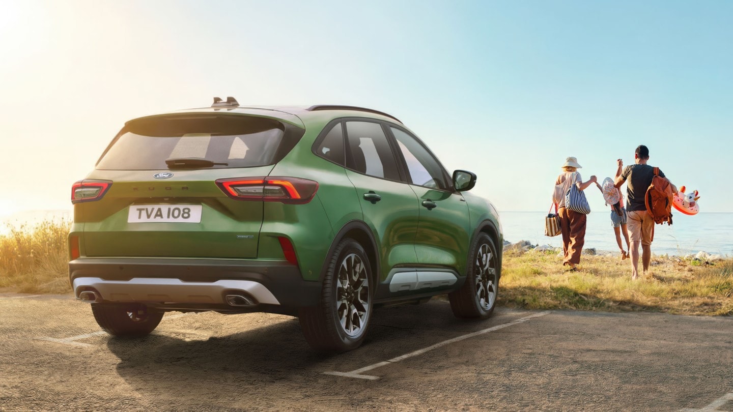 Kuga parcheggiata con persone che camminano verso la spiaggia.