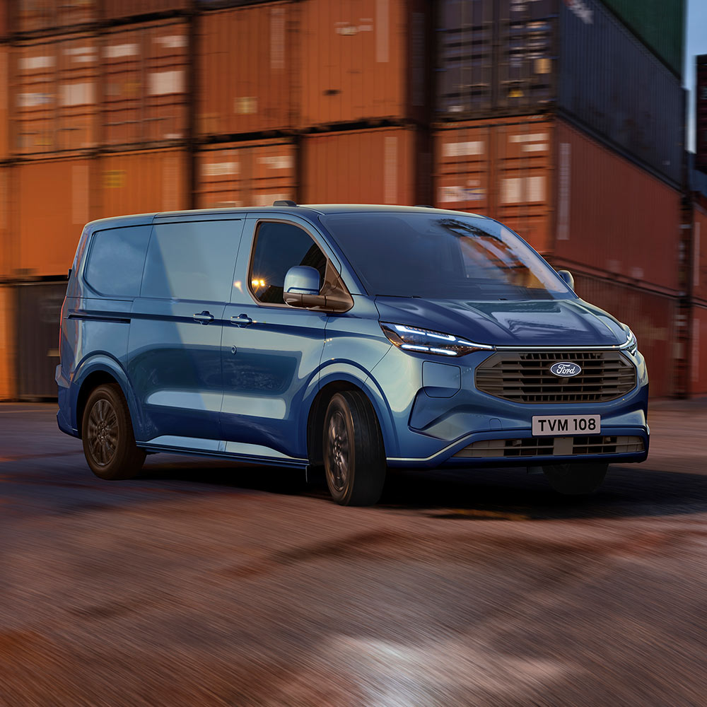 Un furgone Ford Transit Custom Plug-in Hybrid blu attraversa un molo.