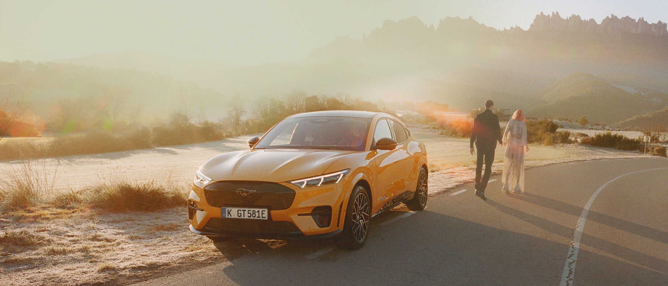 An orange Mustang Mach-E in sunset
