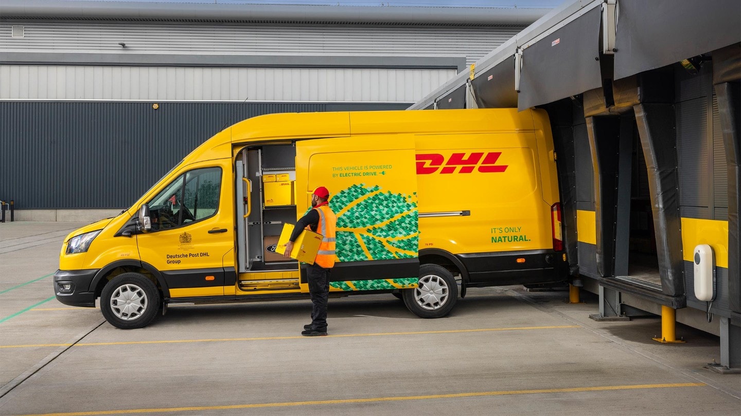 DHL worker with a box near E-Transit