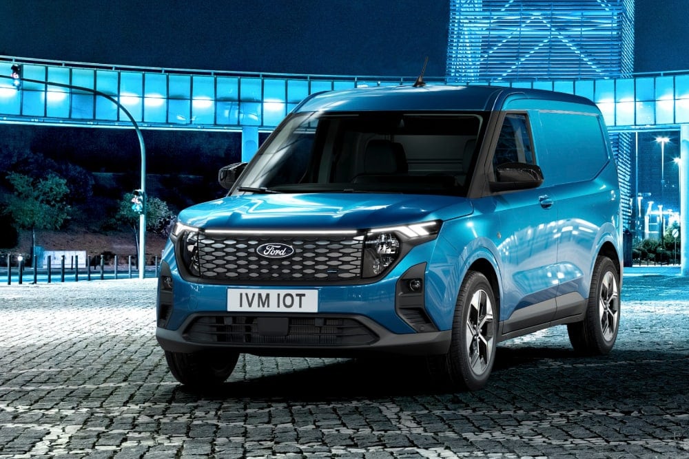 Furgone Ford E-Transit Courier blu di notte in città, illuminato.