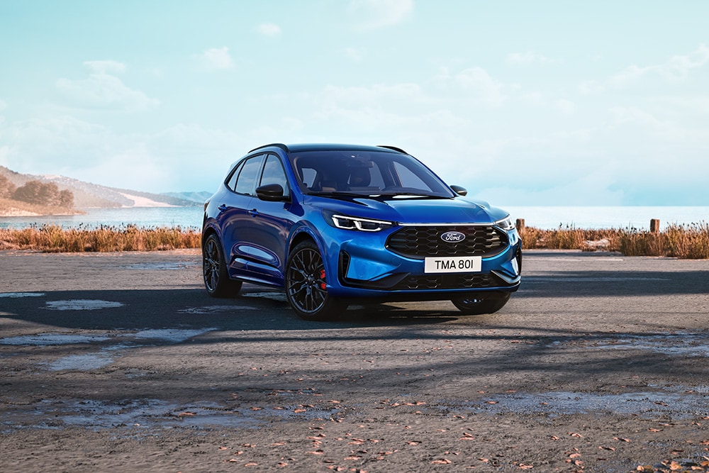 Kuga blu parcheggiata in primo piano su sterrato.