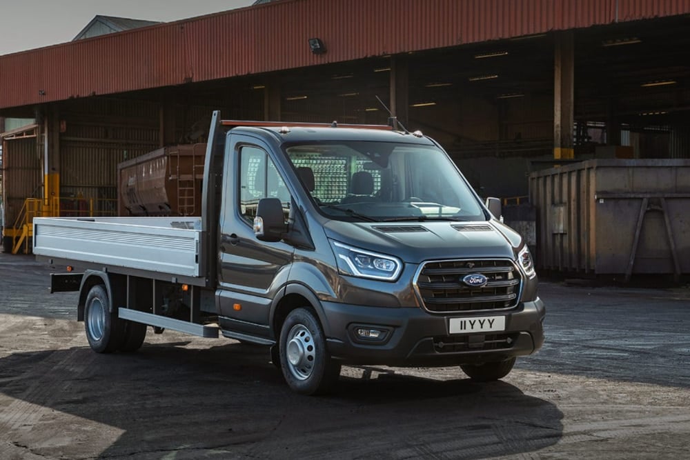 Ford Transit Chassis Cab grigio con pianale, parcheggiato all'aperto.