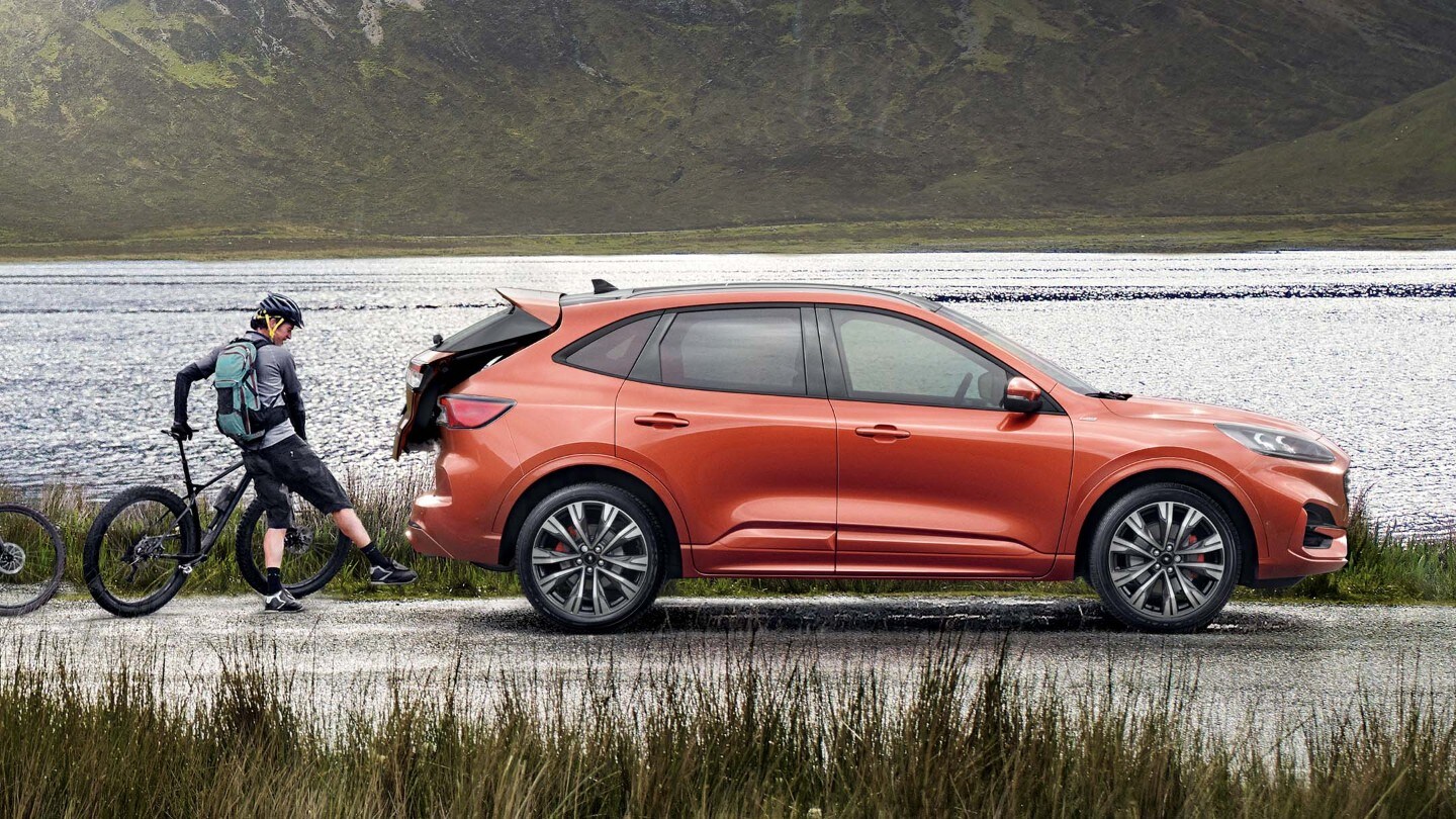 Man putting a bicycle into the trunk of the car