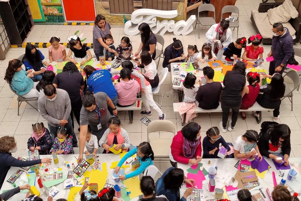 Bambini che si divertono con attività artistiche e manuali durante un evento comunitario organizzato da Ford Philanthropy.