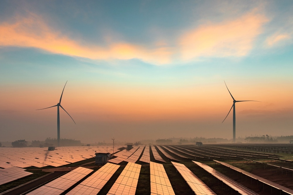 Fonti di energia rinnovabile, tra cui turbine eoliche e pannelli solari, riprese al tramonto.