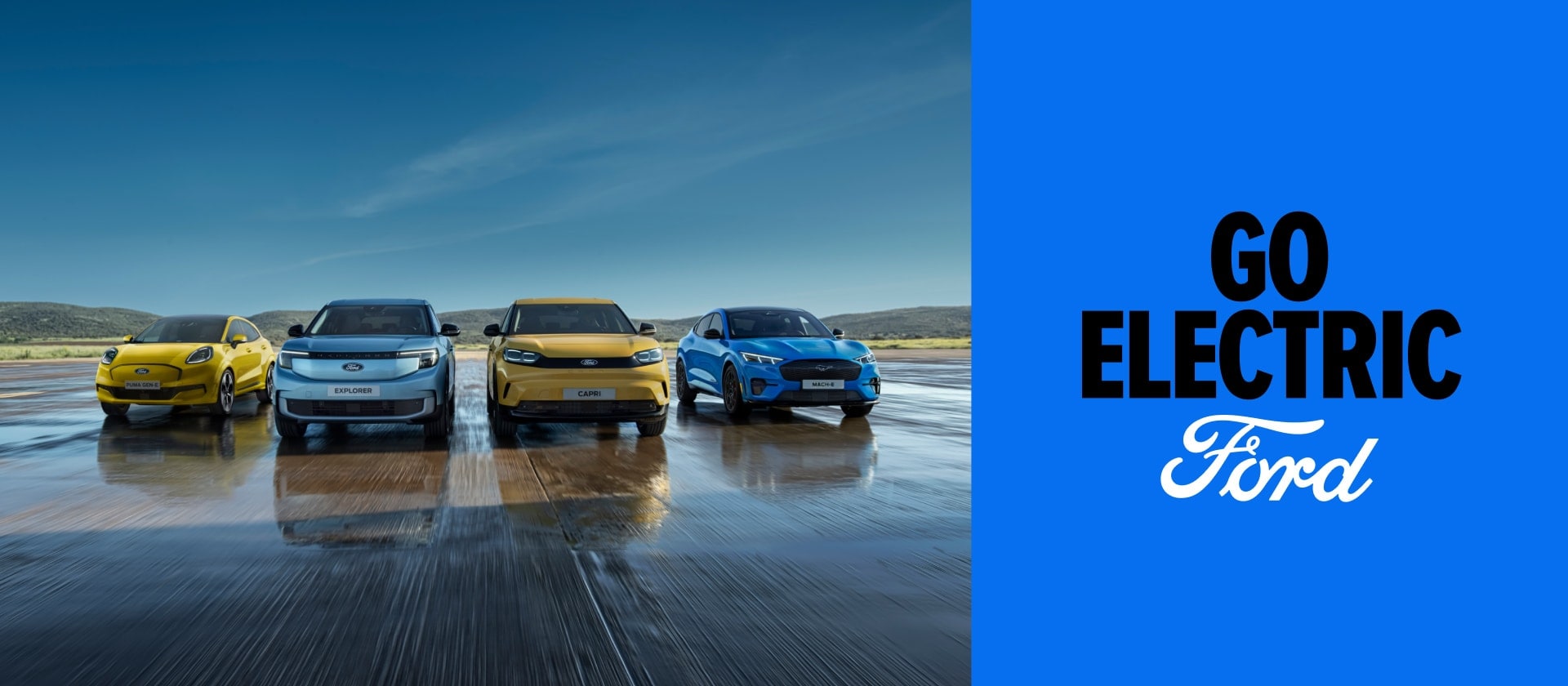 Puma Gen-E, Ford Explorer, Ford Capri e Ford Mustang Mach-E in primo piano mentre percorrono una strada, con il logo Go Electric su sfondo blu.