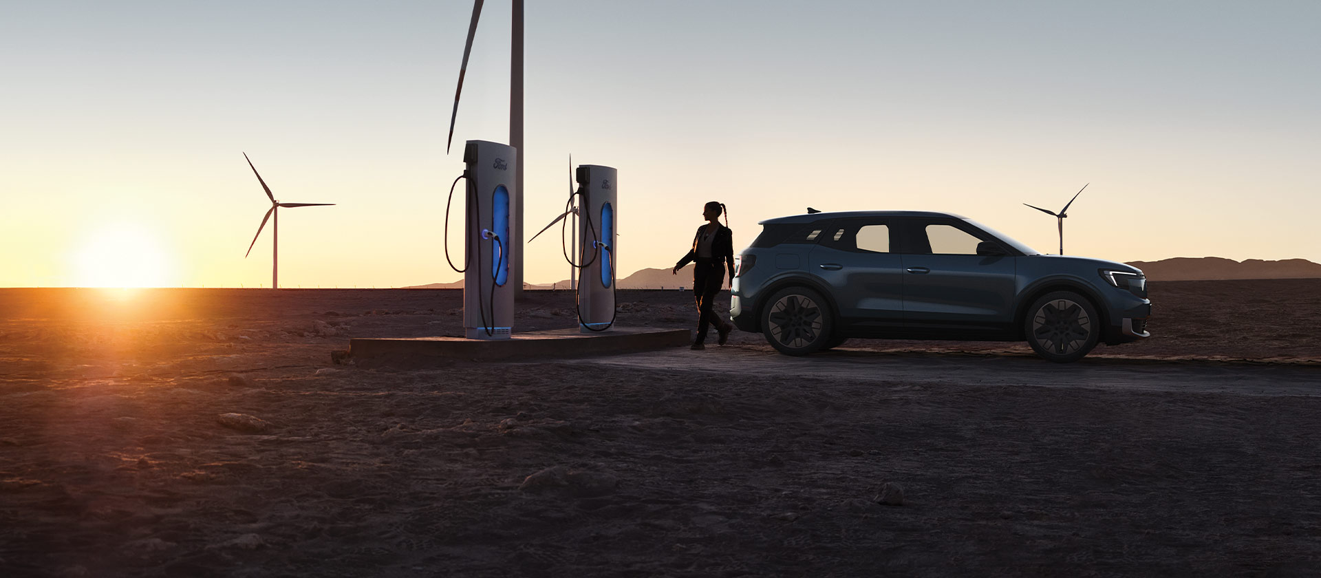  Una persona che ricarica un'auto elettrica Ford presso una stazione di ricarica pubblica.