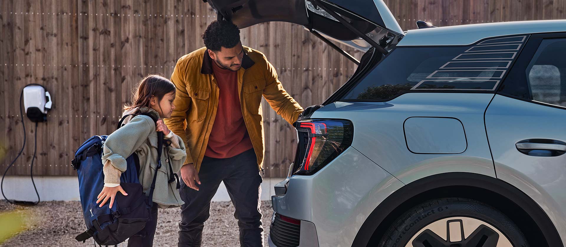 Una famiglia carica il bagagliaio di una Ford Explorer blu.