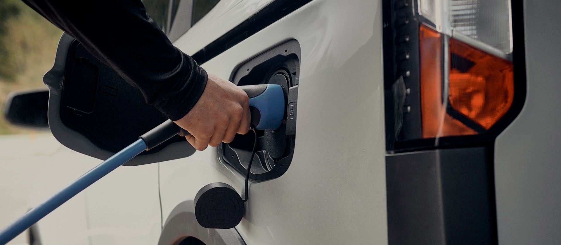 Primo piano di un veicolo elettrico Ford bianco collegato a un caricatore EV.