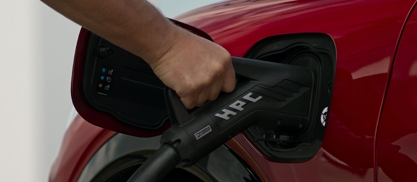 Primo piano di una Ford EV rossa collegata a un caricatore pubblico HPC (High Power Charger), per la ricarica rapida dei veicoli pubblici.