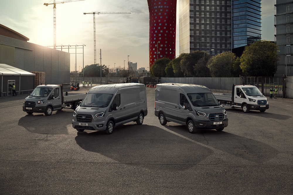La linea di furgoni Ford elettrici e ibridi plug-in parcheggiati all'aperto in un piazzale.