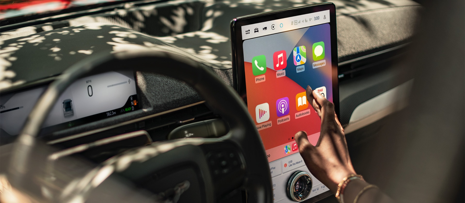 Primo piano del conducente di un Ford Mustang Mach-E mentre utilizza Apple CarPlay sul grande touchscreen SYNC 4 da 15,5". 