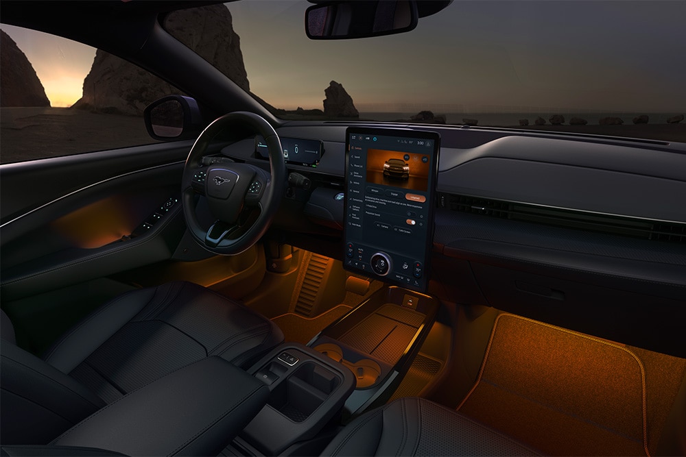 "Interni del Ford Mustang Mach-E: il touchscreen SYNC 4  da 15,5"" e l'illuminazione a LED ambientale impostata sull'arancione"