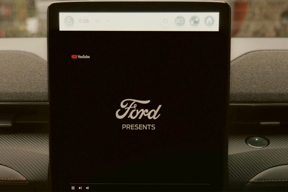Primo piano del touchscreen SYNC 4 da 15,5" con scritta "Ford presents", a dimostrazione dello streaming video in auto