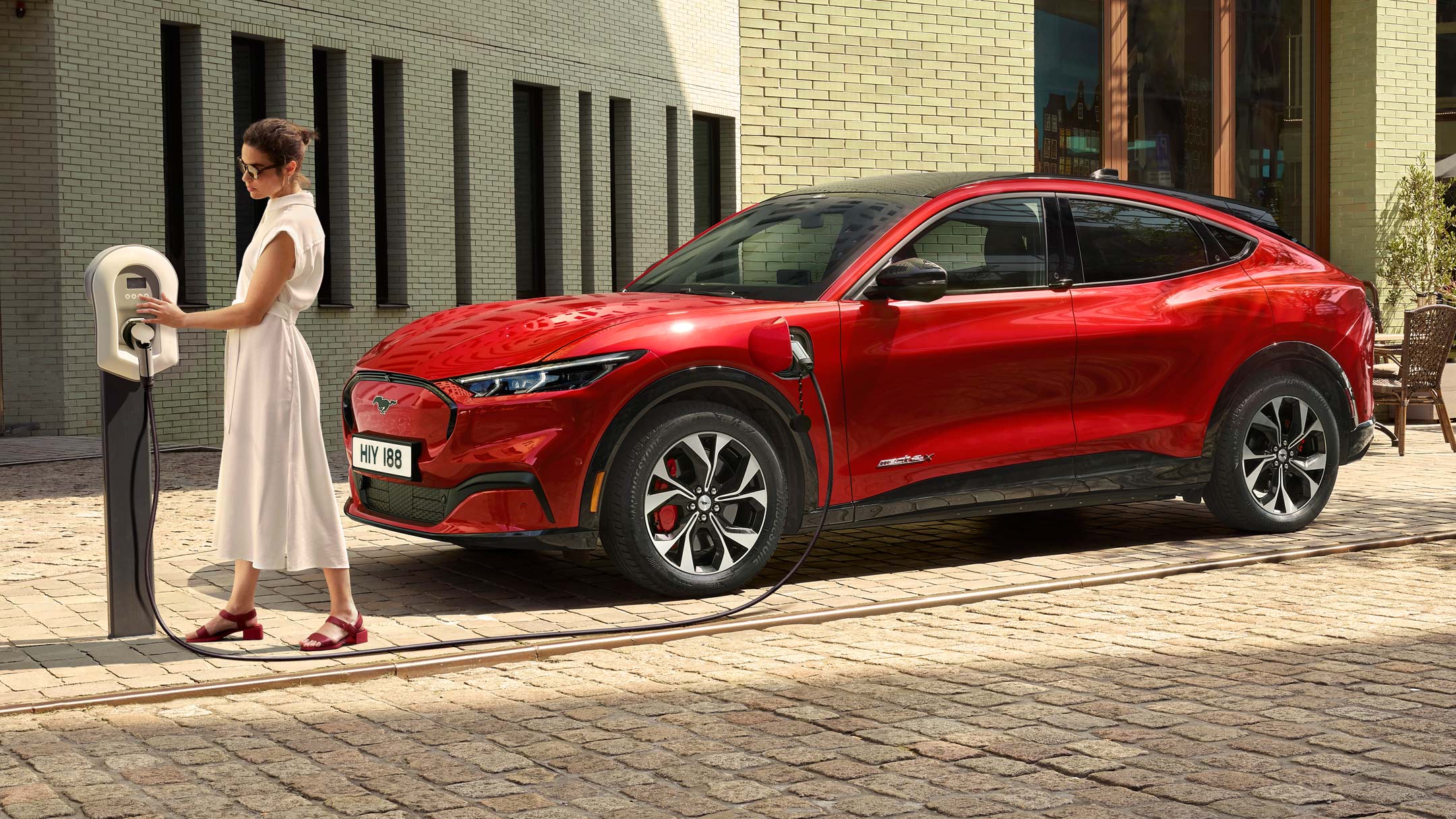 A woman charging an all-new Ford Mustang Mach-E at a public charging point