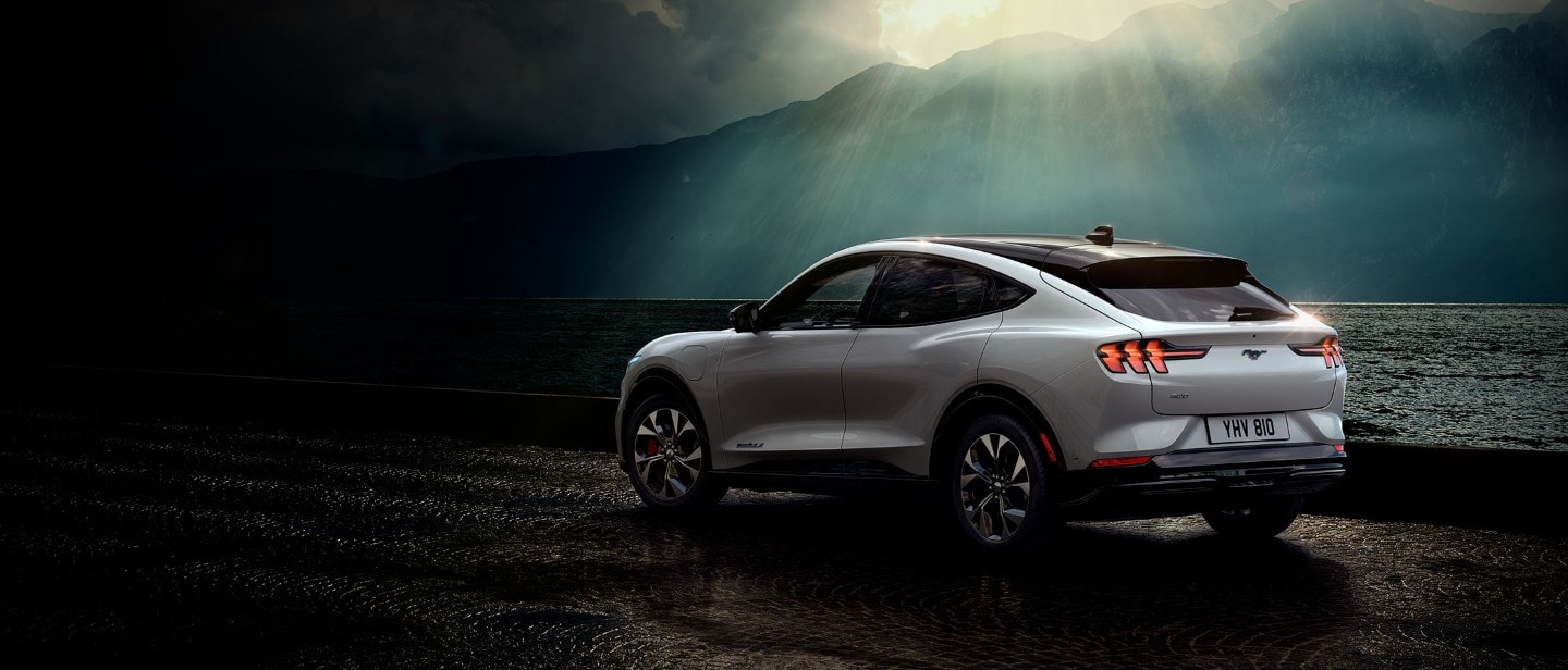 Ford Mustang Mach-E AWD in movimento che costeggia un lago