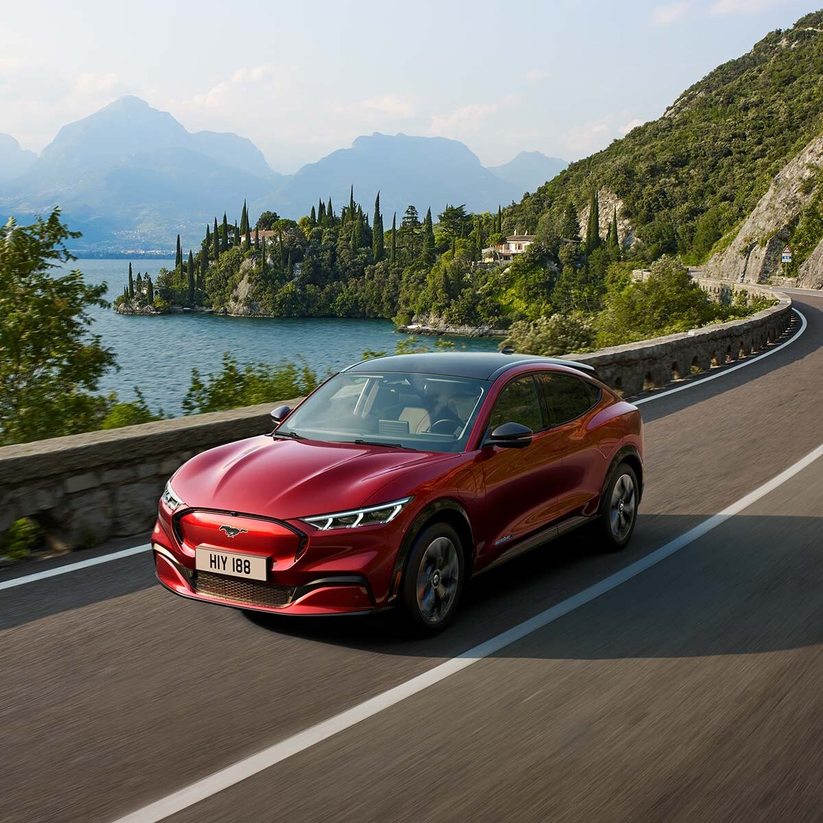 Ford Mustang Mach-E AWD in movimento che costeggia un lago