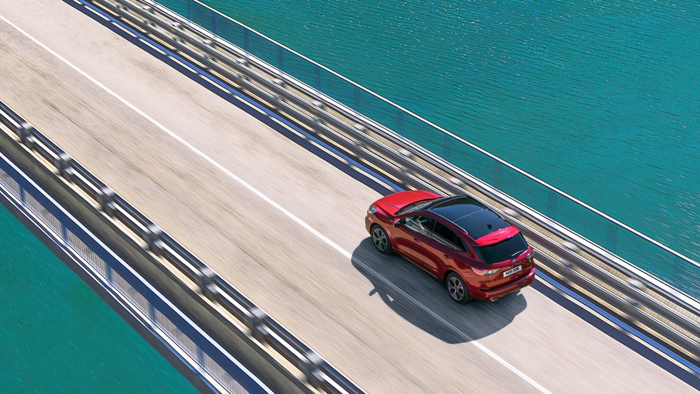 Ford Kuga rossa che viaggia sul ponte sopra l'acqua