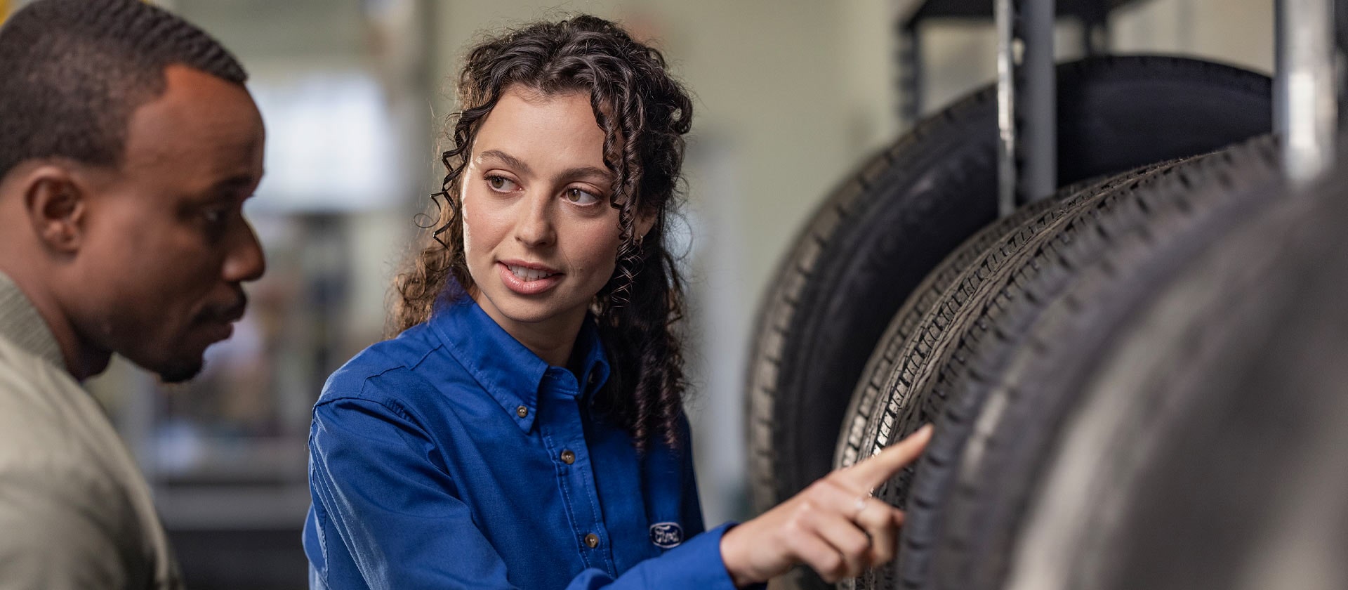 Uno specialista di riparazioni Ford aiuta un cliente con i nuovi pneumatici della sua Fiesta