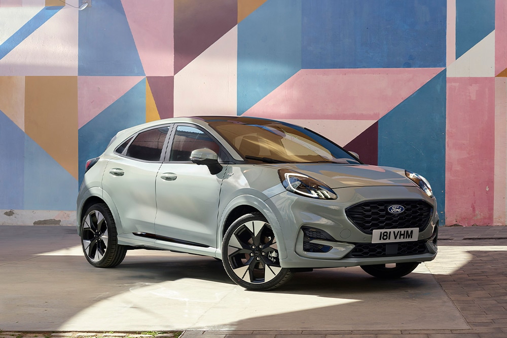 Ford Puma grigia parcheggiata di fronte a un murale