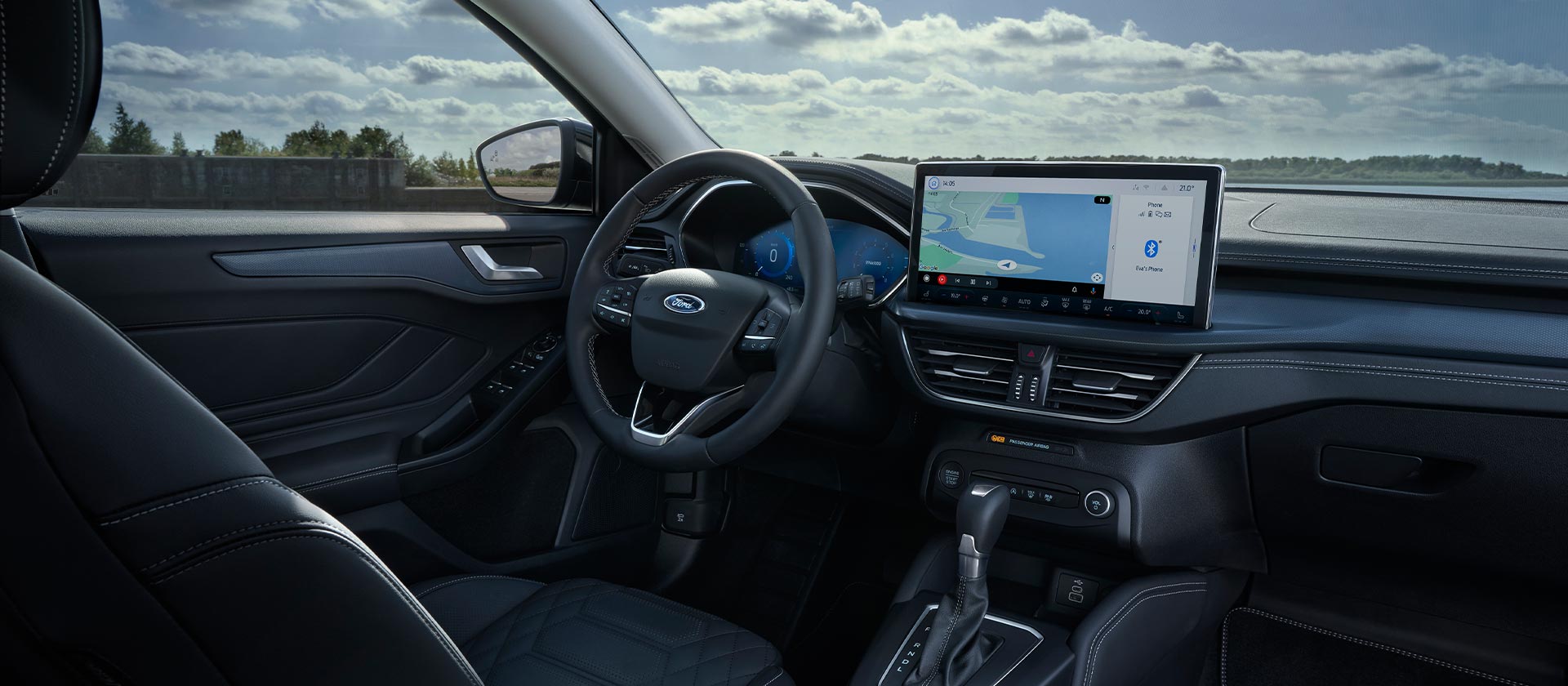 Visuale degli interni della Ford Focus, viene mostrato il cruscotto, il volante e lo schermo di infotainment con la navigazione.