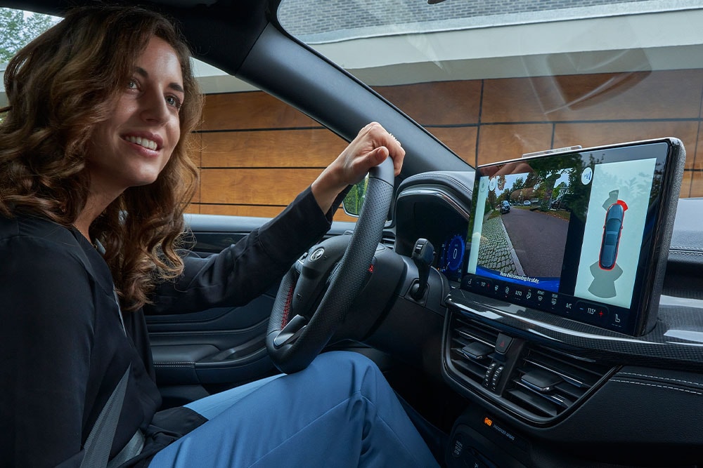 Donna seduta al posto di guida di una Ford Focus.