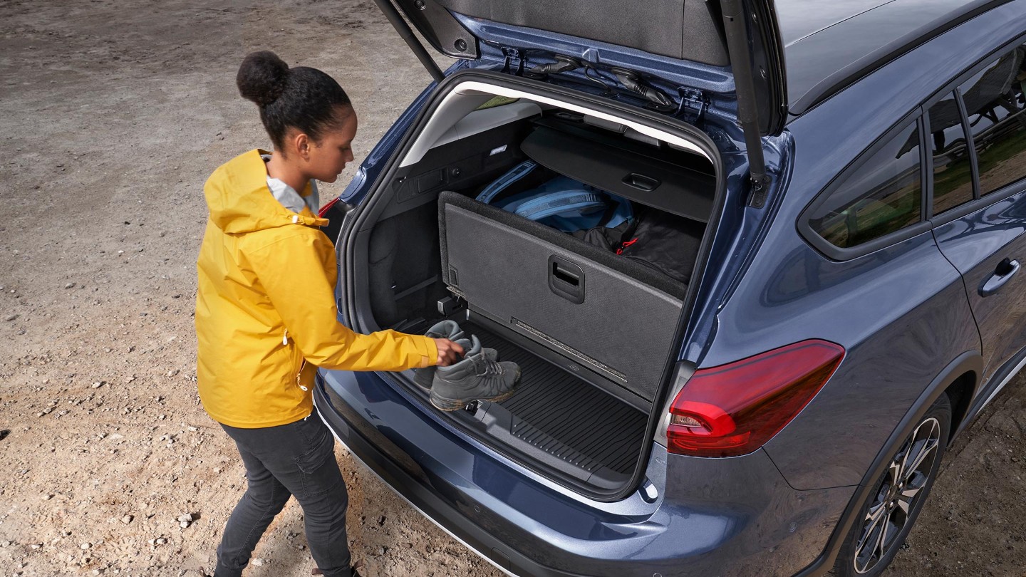 Woman loading a pair of shoes into a Ford Focus