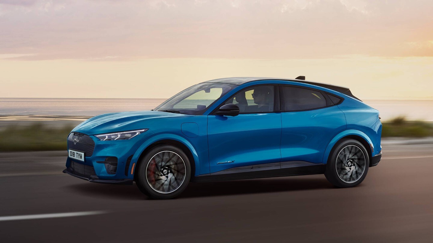 Ford Mustang Mach-E GT, in movimento lungo una strada, il lago sullo sfondo