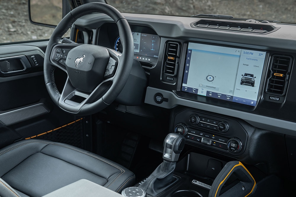 Vista degli interni del Ford Bronco, con volante in pelle e touchscreen connesso.