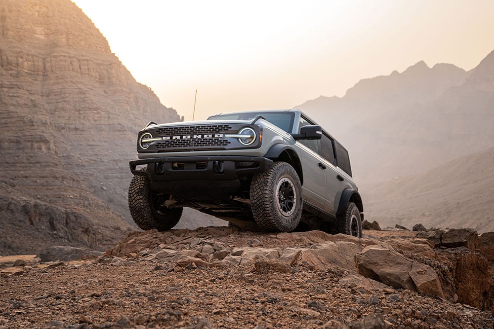 Un Ford Bronco grigio parcheggiato su un percorso roccioso in montagna.