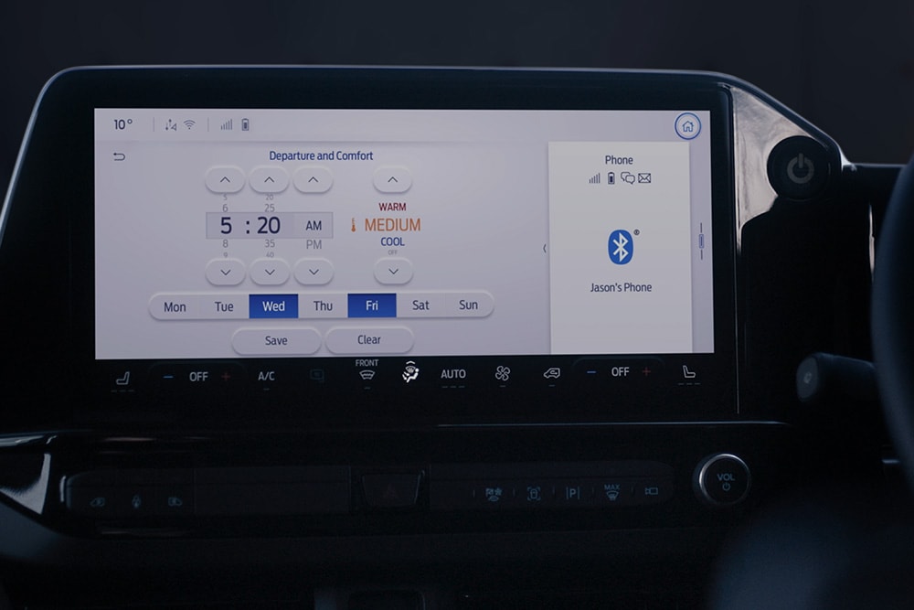 La schermata della dashboard dell'E-Tourneo Custom mostra le impostazioni di partenza e comfort, tra cui il pre-condizionamento programmato.