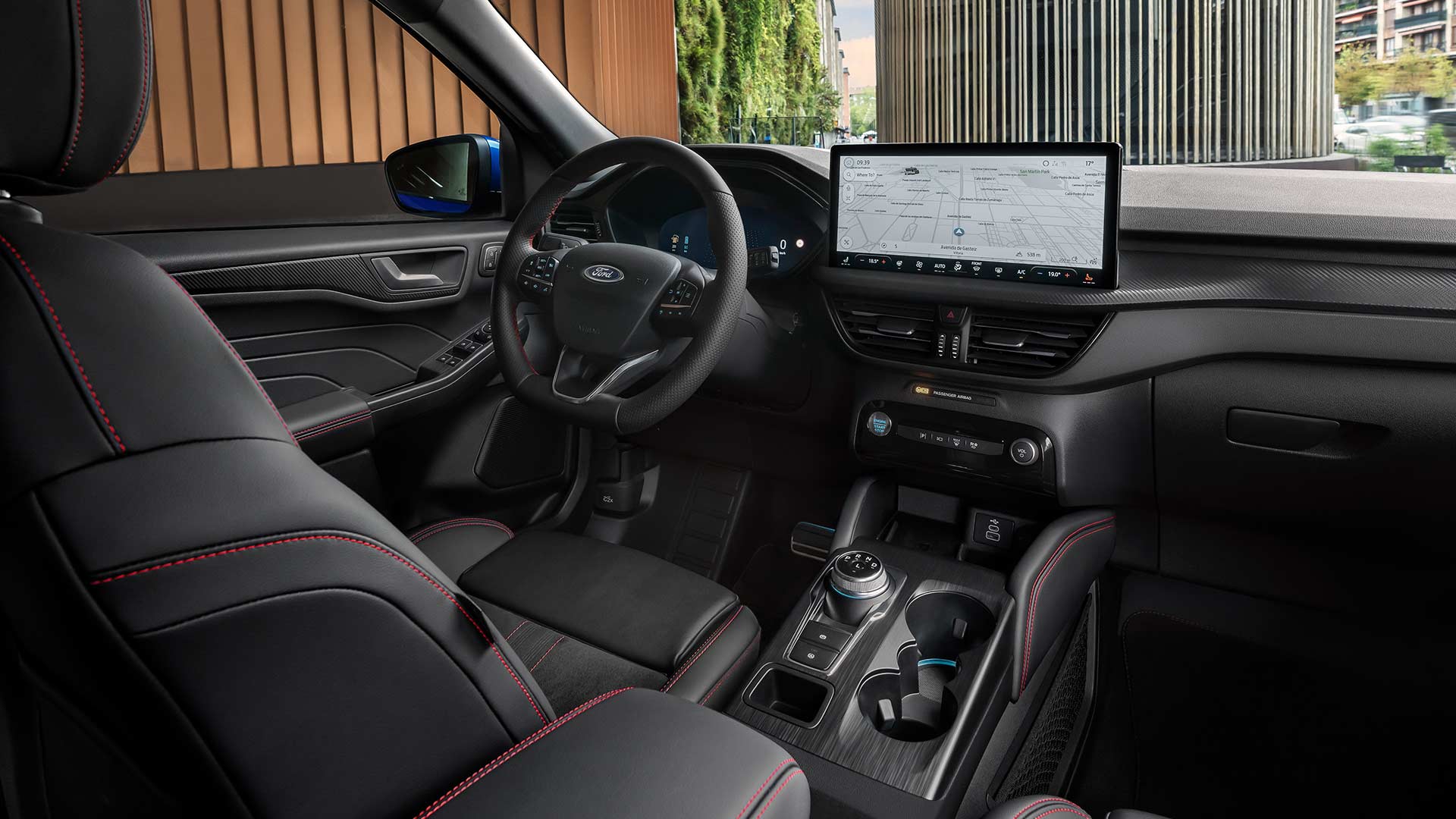 nellaterni della Ford Kuga che mostrano il volante con logo Ford, l'ampio touchscreen SYNC® 4 e i sedili neri con cuciture rosse.