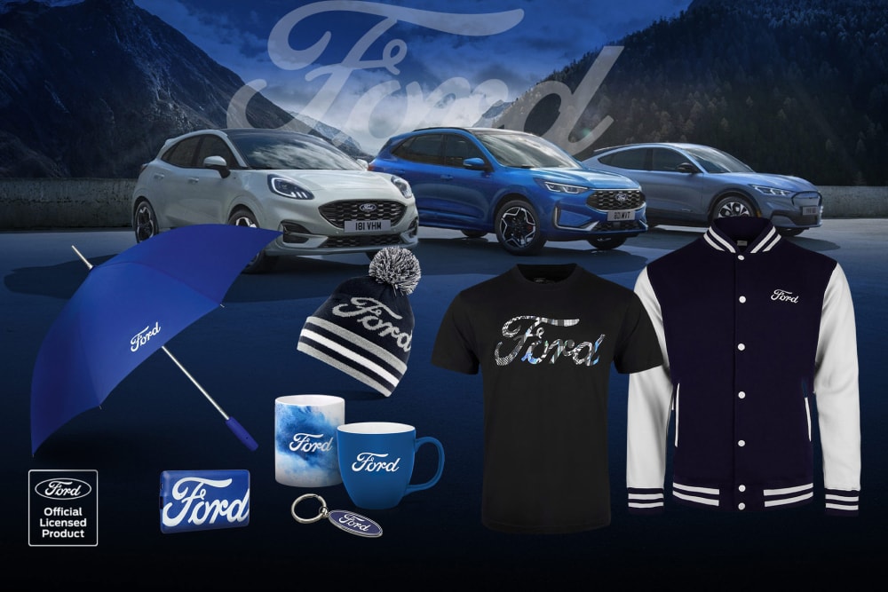 Collezione di merchandising Ford con vari veicoli Ford sullo sfondo, ombrello brandizzato Ford, tazza e abbigliamento.