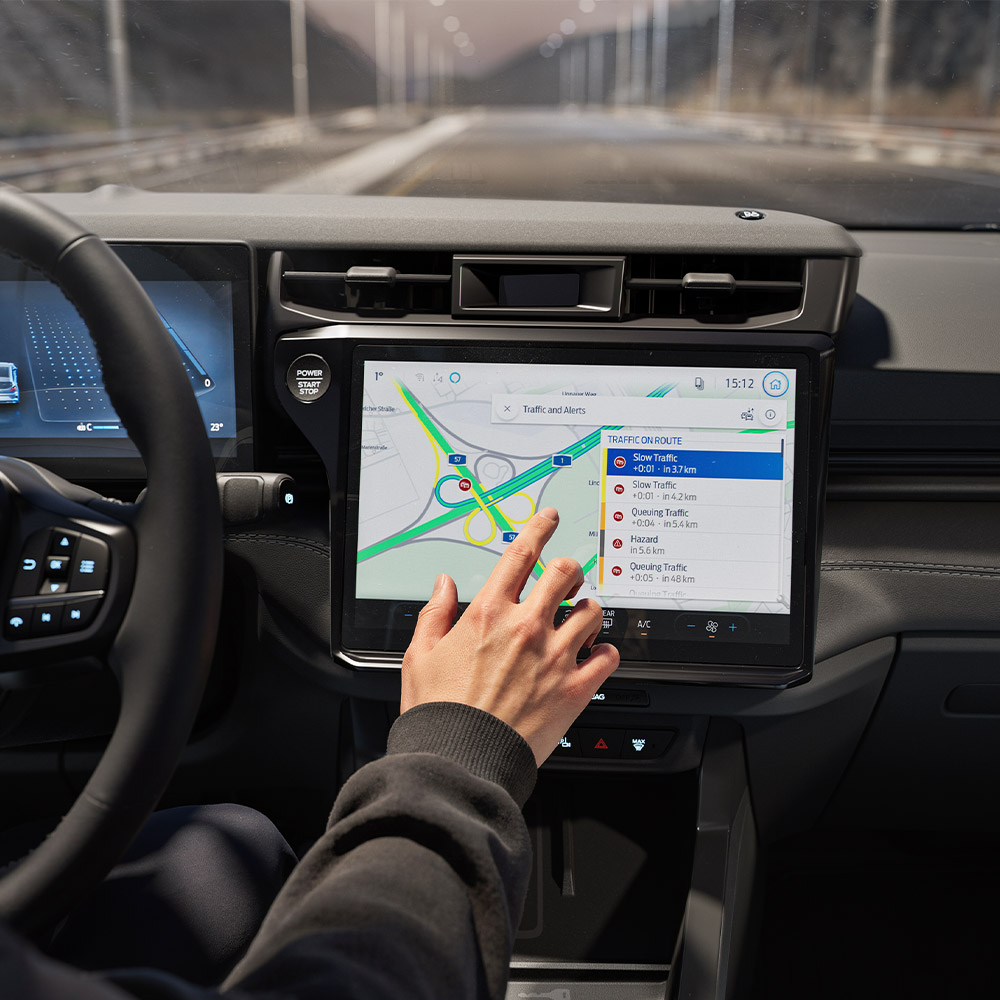 Un conducente usa la funzione di navigazione connessa sullo schermo digitale di un Ford Puma Gen-E BlueCruise Edition.