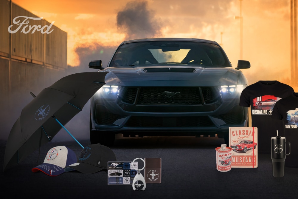 Collezione Ford Mustang con una Mustang grigia sullo sfondo e merchandising Mustang con ombrello, cappellini, tazze e t-shirt.