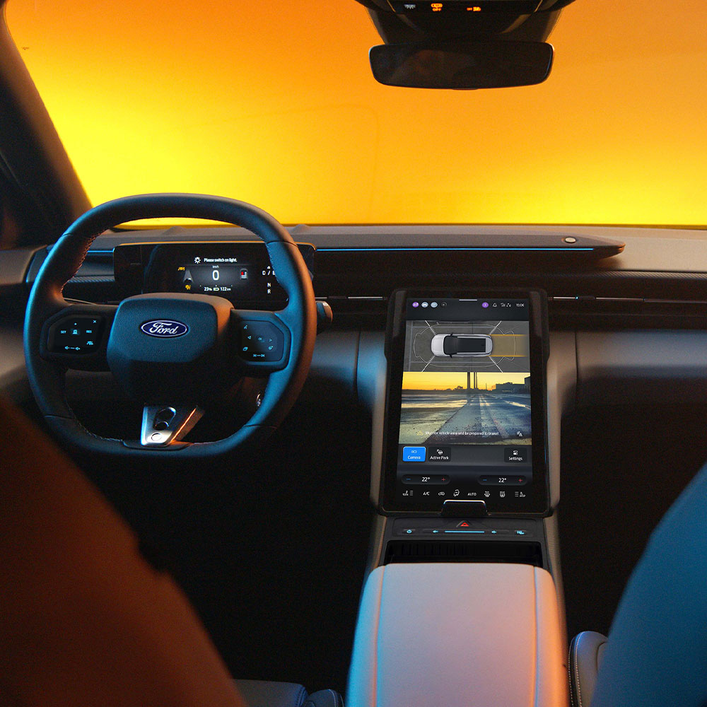 Primo piano del touchscreen del nuovo Ford Capri® con telecamere a 360° e tecnologia di assistenza attiva al parcheggio.