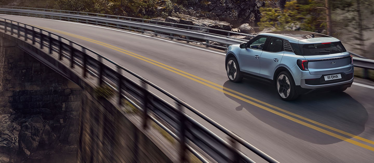 A rear view of Ford Explorer® driving through a forest