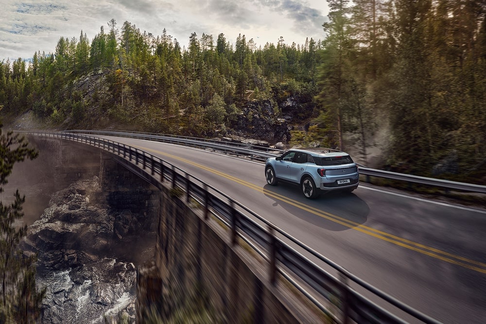 SUV familiare Ford Explorer blu in viaggio su una strada di montagna.
