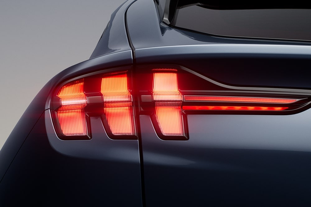 Primo piano su una luce posteriore tripla accesa di Ford Mustang Mach-E sportivo.