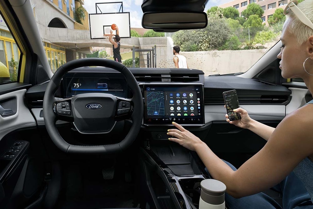 Interno di un'auto piccola Ford Puma Gen-E, con visibilità sui comandi del touchscreen.