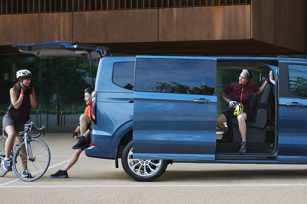Side view of the All-New Tourneo Custom with peopel around it 