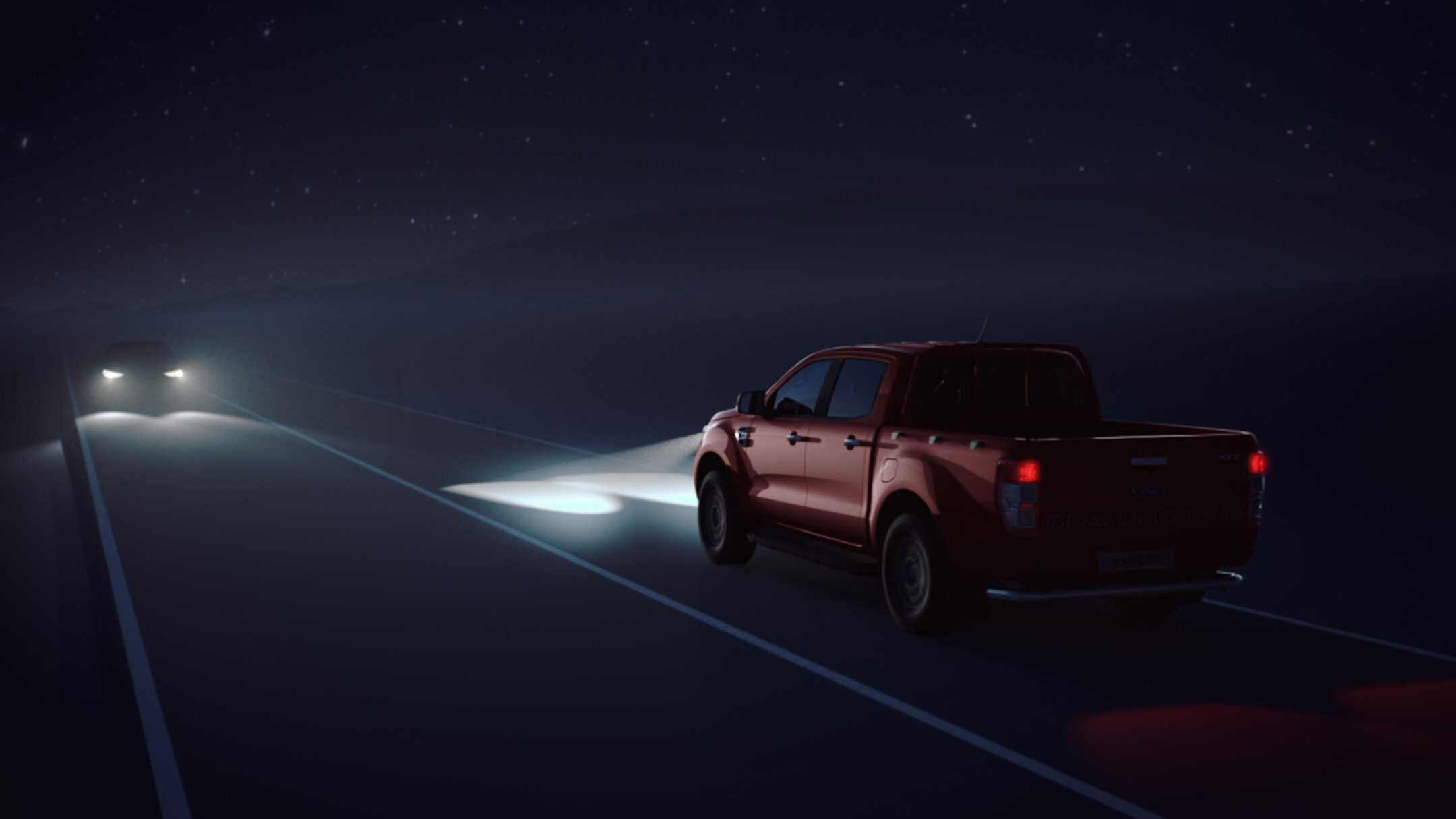 Ford Ranger di colore rosso in movimento di notte con fari accesi