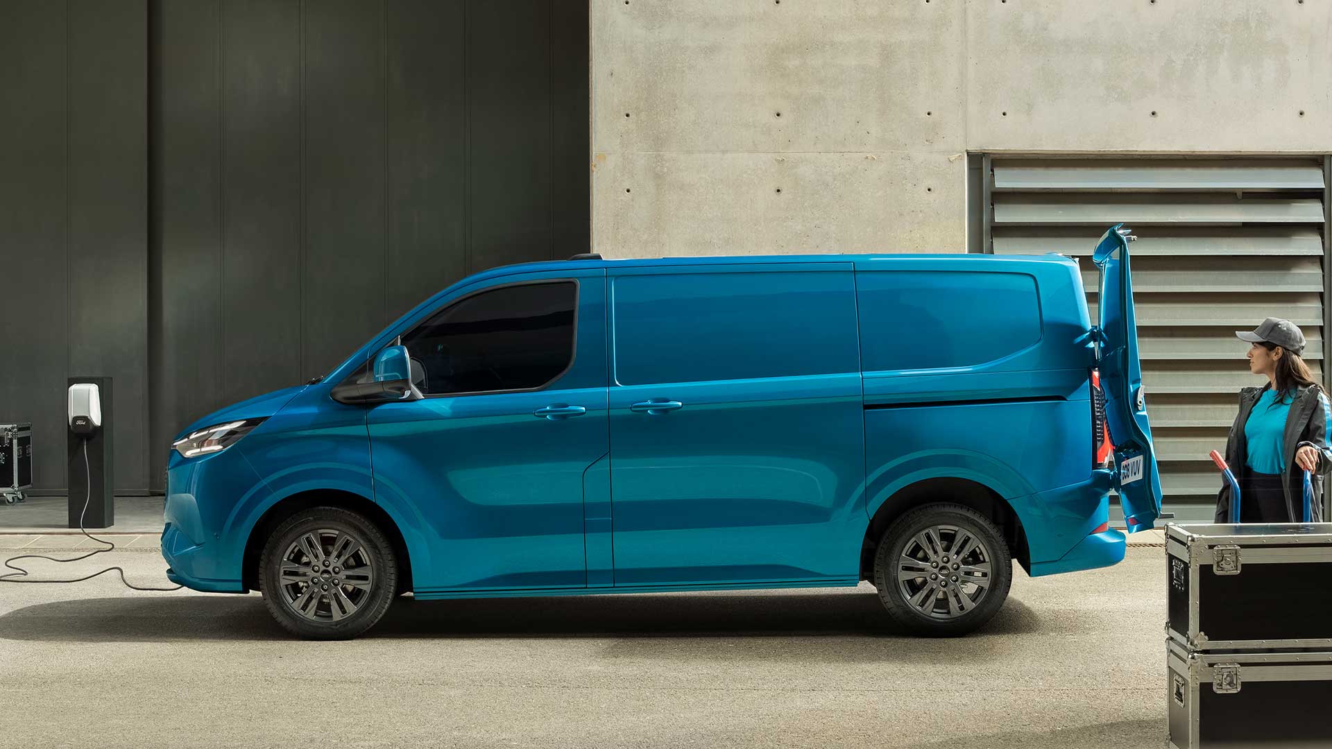 Un furgone elettrico Ford E-Transit Custom blu in carica.