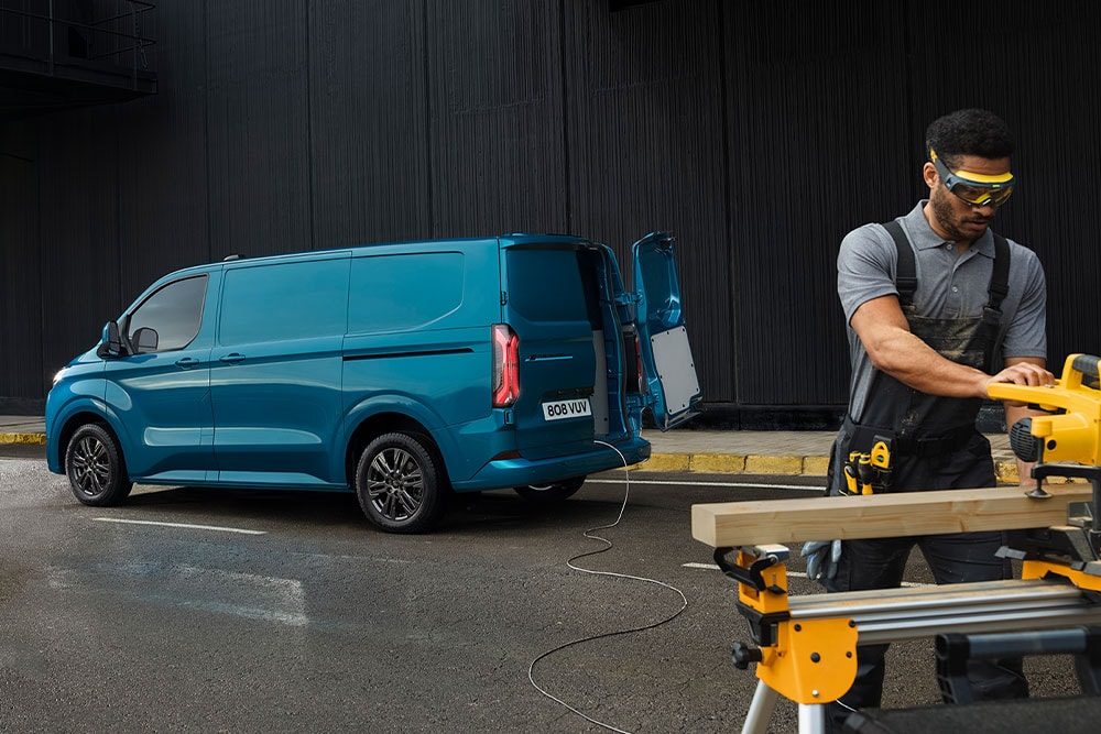 Un furgone Ford Transit Custom blu e una persona che utilizza utensili elettrici.