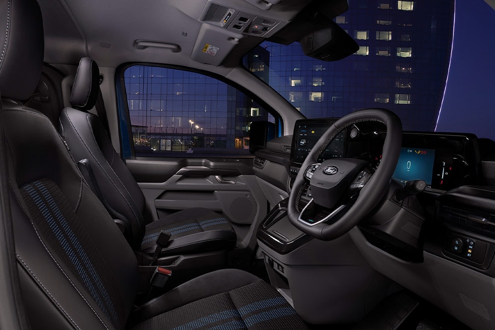 Interni del furgone elettrico Ford E-Transit Custom, con sedili del conducente e del passeggero.