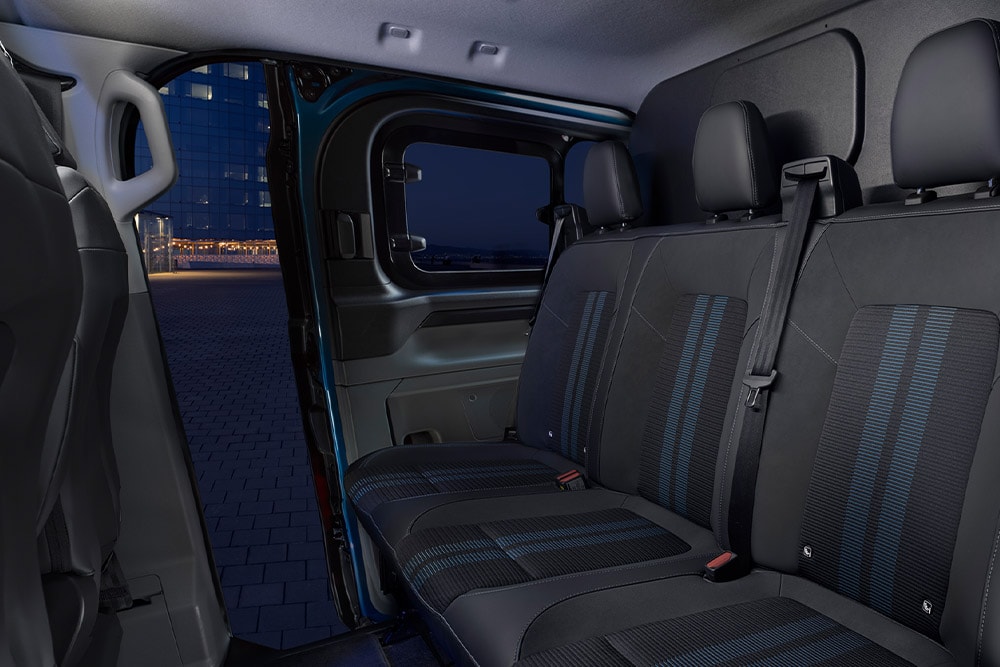 Vista posteriore di un furgone a doppia cabina Ford E-Transit Custom Sport blu.