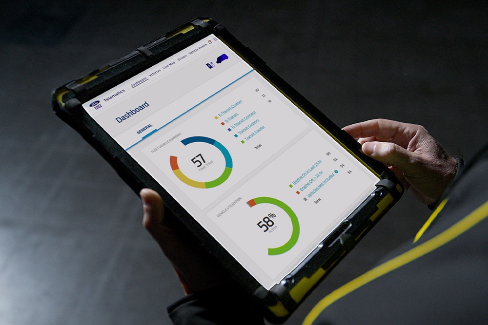 Una persona regge un tablet che mostra i dati del veicolo Ford Pro.