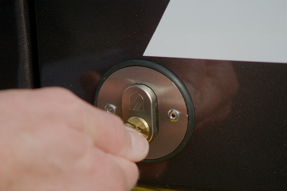 Una mano chiude la portiera di un furgone con una chiave.